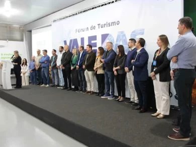 O turismo regional tem provado ser uma poderosa ferramenta de desenvolvimento no oeste catarinense, conectar cultura, natureza e empreendedorismo local. Com esse espírito, o 3º Fórum de Turismo da Instância de Governança Regional (IGR) Vale das Águas reuniu, nesta semana, em Pinhalzinho, representantes dos 27 municípios que integram a região para fortalecer laços, compartilhar experiências e impulsionar estratégias de crescimento sustentável. O evento, realizado com o apoio do Sebrae/SC, mostrou que o turismo vai além da visitação: é um caminho concreto para gerar renda, fixar pessoas no campo e valorizar o que cada território tem de mais belo. “O Fórum foi um momento estratégico de integração entre o setor público, a iniciativa privada, empreendedores e entidades de apoio, como o Sebrae/SC, que atua como um dos principais parceiros do turismo na região. Estima-se que mais de 70% dos projetos turísticos desenvolvidos no oeste catarinense contam com o nosso apoio em fomentar os atrativos, apresentando cases e mostrando iniciativas que deram certo, que são essenciais para a manutenção desta atividade”, salientou a analista de negócios do Sebrae/SC, Marieli Aline Musskopf. A anfitriã do evento, prefeita em exercício de Pinhalzinho, Franciéli Werlang, destacou a satisfação do município em sediar a terceira edição do Fórum de Turismo do Vale das Águas. “É uma alegria muito grande receber esse importante encontro, que envolve 27 municípios da nossa região. Sabemos da relevância de incentivar o turismo como uma nova matriz econômica, promovendo a diversidade e fortalecendo o desenvolvimento local”, afirmou. VALORIZANDO O LOCAL A programação do evento incluiu palestras com nomes de destaque no cenário turístico estadual e nacional. O vice-prefeito e secretário de Turismo de Bombinhas, José Antônio Olímpia, compartilhou as Boas Práticas de Gestão Pública que contribuíram para posicionar Bombinhas como referência em turismo sustentável. “O trabalho começa com a aceitação da comunidade. É preciso que ela esteja disposta a receber o turista, em parceria com a prefeitura e o empresariado”, afirmou Olímpia. Segundo ele, na cidade, o turismo foi estruturado com base nos pescadores e maricultores, enquanto, no oeste, o grande potencial está na agricultura e no meio rural. Olímpia salientou ainda que, assim como ocorreu em Bombinhas no passado, o oeste enfrenta o desafio de evitar o êxodo dos jovens. “Muitos acabam não dando continuidade à cultura local porque saem para estudar e empreender em grandes centros. O ideal é que permaneçam e encontrem no turismo uma forma de manter a cultura e a raiz familiar”, defendeu. Entre as recomendações, enfatizou a importância da formalização dos negócios, da capacitação dos empreendedores e da criação de roteiros turísticos que envolvam o cotidiano das famílias rurais. “O turista hoje busca experiências autênticas, quer viver o dia a dia da comunidade, não apenas visitar”, pontuou. Ele citou o potencial da região para o turismo rural, especialmente com a valorização do frio, dos chalés e do contato direto com a natureza e a cultura local. O vice-prefeito também reforçou o papel de iniciativas como o Programa Cidade Empreendedora e as Salas do Empreendedor, que ajudam a preparar os pequenos negócios para atender melhor os visitantes. Em Bombinhas, inclusive, está prestes a ser lançada uma nova Rota da Tainha, exemplo de como valorizar produtos locais com identidade turística. FOMENTANDO O TURISMO A coordenadora estadual de Turismo do Sebrae/SC, Aline Miranda, apresentou e lançou o projeto Viva Santa Catarina, voltado ao fomento do turismo de experiência e à qualificação do receptivo turístico, uma carência identificada na região. Ela ressaltou que a atividade é uma construção coletiva e territorial, e que os avanços não ocorrem de forma isolada. “Ninguém faz nada sozinho no turismo. É preciso conexão entre pessoas, entre cidades e entre ideias. Nosso desafio agora é fazer com que esses turistas permaneçam mais tempo aqui, conheçam o que essa região tem a oferecer, e não apenas passem direto rumo ao litoral”, pontuou. O projeto visa formar e capacitar guias, agências de turismo receptivo, condutores locais, motoristas, profissionais de tecnologia com potencial de formalização, entre outros, promovendo a valorização do território, a identidade local e o acesso ao mercado. “Estamos iniciando uma nova era para o turismo do oeste, com foco em formar quem vai receber bem, contar histórias e encantar quem chega”, concluiu Aline. CASES DE SUCESSO Além das palestras, foram apresentados três cases de sucesso que ilustram como o turismo vem transformando realidades no oeste e extremo oeste catarinense. Em Formosa do Sul, a Área de Lazer Chico Mendes, gerida por jovens empreendedores rurais, consolidou-se como uma alternativa ao êxodo rural, oferecendo chalés, trilhas, tirolesa e museu. Em Nova Erechim, o Mirante Sol Nascente se tornou ponto turístico de contemplação, com vista para o nascer do sol sobre dez municípios. Já em Quilombo, o Refúgio das Quedas foi criado por Daiane Conci em homenagem ao pai e hoje atrai turistas com hospedagem em meio à natureza, próximo às quedas do Rio Chapecó. Entre os participantes do Fórum, também estiveram presentes empreendedores que já atuam no setor turístico regional, como Daniel Palombit, do Termas São João, empreendimento com duas décadas de história. Para ele, o evento foi uma oportunidade de qualificar ainda mais a equipe. “Buscamos em um evento como esse capacitar nossos funcionários, trocar experiências e entender o que está funcionando”, afirmou. O empresário também compartilhou sua experiência com a consultoria do Sebrae/SC, parceria que já dura cerca de 10 anos. “Através do Sebrae/SC, tivemos acesso a diversos cursos e orientações importantes. Sempre que precisamos de algo, a entidade está junto, auxiliando e apontando caminhos”, disse. Segundo ele, esse suporte técnico foi fundamental para aprimorar a gestão e identificar oportunidades de inovação no negócio. INSTÂNCIA DE GOVERNANÇA REGIONAL (IGR) VALE DAS ÁGUAS A Instância de Governança Regional Vale das Águas é uma das regiões turísticas definidas pelo Ministério do Turismo e reúne municípios do oeste e extremo-oeste catarinense que compartilham uma oferta similar de atrativos, especialmente voltados ao turismo de natureza e às águas termais. Entre os destaques naturais da região estão os rios Uruguai e Chapecó, além de um crescente interesse por ecoturismo e turismo de contemplação. Fonte: Sebrae/SC