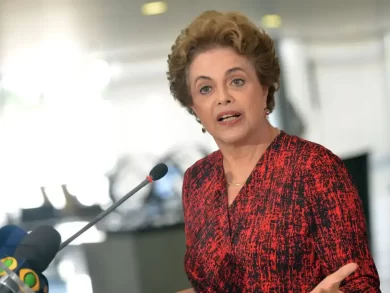 Ao participar da cerimônia de 10 anos do Novo Banco de Desenvolvimento (NDB, na sigla em inglês), a presidente da instituição, Dilma Rousseff, avaliou que o desenvolvimento deve ser sustentável, inclusivo, justo, resiliente e soberano. “Comemoramos, portanto, a primeira década do banco não só com orgulho, mas com senso renovado de propósito”. “O mundo de hoje não é o mesmo de 2015. Está mais fragmentado, mais desigual e mais exposto a crises sobrepostas – crises climáticas, econômicas, geopolíticas. O multilateralismo está sob pressão. Testemunhamos um recuo na cooperação e o ressurgimento do unilateralismo.” Segundo Dilma, tarifas, sanções e restrições financeiras estão sendo utilizadas como “ferramenta de subordinação política”. “Cadeias produtivas globais estão sendo reestruturadas, não apenas pela busca de mais eficiência, mas sim por interesses geopolíticos”. “E o sistema financeiro internacional continua profundamente assimétrico, colocando os fardos mais pesados sobre aqueles com menos recursos. O cenário exige mais e não menos cooperação. E exige instituições que reflitam as realidades e as aspirações do mundo de hoje, não somente do mundo de oito décadas atrás, explicou”. Para Dilma, a missão proposta pelo NDB segue “não apenas relevante, mas essencial”. “Demonstramos, nos últimos 10 anos, que é possível construir uma instituição confiável, eficiente e adaptável, que produz resultados reais e, ao mesmo tempo, defende os valores da solidariedade, equidade e soberania”. “Não temos o objetivo de substituir quem quer que seja. Porém, buscamos provar que há mais de uma maneira de promover o desenvolvimento. E os países emergentes e em desenvolvimento merecem instituições que compreendam seus desafios, respeitem suas escolhas e apoiem suas ambições”, concluiu. Entenda Criado em 2015, o New Development Bank ou Novo Banco de Desenvolvimento, também conhecido como Banco do Brics, é um banco multilateral de desenvolvimento criado para mobilizar recursos para financiar projetos de infraestrutura e de desenvolvimento sustentável em países em desenvolvimento. De acordo com o site da instituição, o NDB já aprovou um total de 120 projetos e US$ 39 bilhões (o equivalente a mais de R$ 210 bilhões) em financiamentos. Países fora do Brics, como o Uruguai, a Argélia e Bangladesh, também podem fazer parte da instituição. Os fundadores do Brics, entretanto, são os maiores depositantes de recursos do banco de fomento. A Colômbia também manifestou interesse em se tornar integrante. A entrada no Brics, por outro lado, não garante acesso direto ao NDB. Em 2023, a ex-presidente Dilma Rousseff foi escolhida presidente do NDB, sendo reeleita em 2025. Brics O bloco se define como um foro de articulação político-diplomática de países que formam o chamado sul global, buscando cooperação internacional e tratamento multilateral de temas globais. Além de buscar mais influência e equidade de seus integrantes em instituições como a Organização das Nações Unidas (ONU), o Fundo Monetário Internacional (FMI), o Banco Mundial e a Organização Mundial do Comércio (OMC), o Brics tem em seu radar a criação de instituições voltadas para seus participantes, como o NDB. Por não constituir uma organização internacional, o Brics não tem orçamento próprio ou secretariado permanente.
