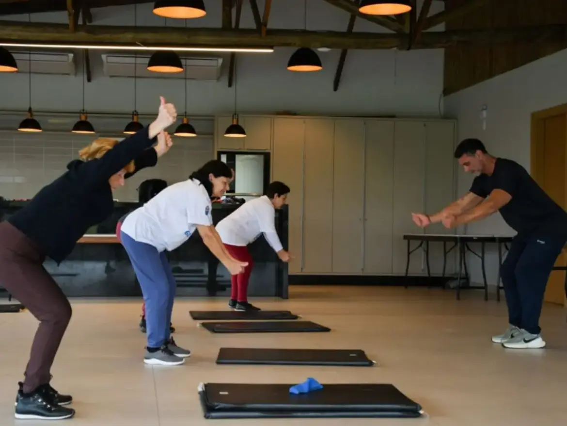 Aula de ginástica ou fortalecimento em grupo, com três participantes idosas e um instrutor